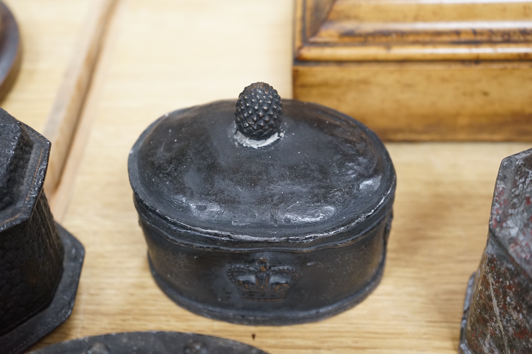 A collection of eleven early 19th century lead tobacco boxes to include an octagonal example with remains of red paint, largest 13cm wide